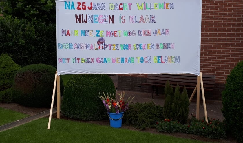 Het spandoek - mét gladiolen - dat buren plaatsten als hulde voor hun buurvrouw Willemien. Foto: PR
