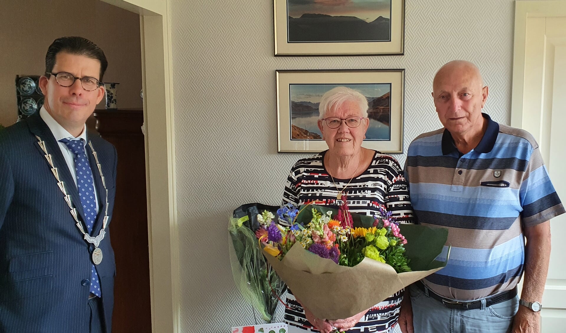 Het echtpaar Meijer heeft van burgemeester Joost van Oostrum de felicitaties en een mooi boek bloemen in ontvangst genomen. Foto: Rob Weeber