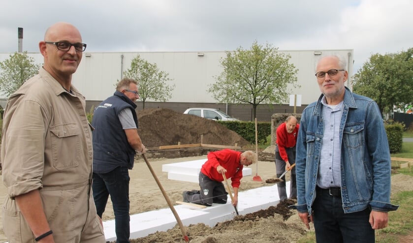 Rene te Selle (l) en Ben Aardeman kijken toe hoe de vrijwilligers de isolatie aanbrengen voor de toekomstige werkplaats. Foto: Lineke Voltman