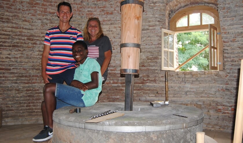 Arno en Hélène met Jean Marc bij de molensteen in de Coops Molen. Foto: Contact