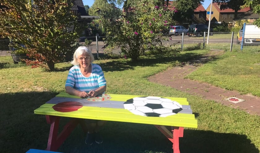 Elly Willems bij een van de door haar geverfde bankjes. Foto: PR