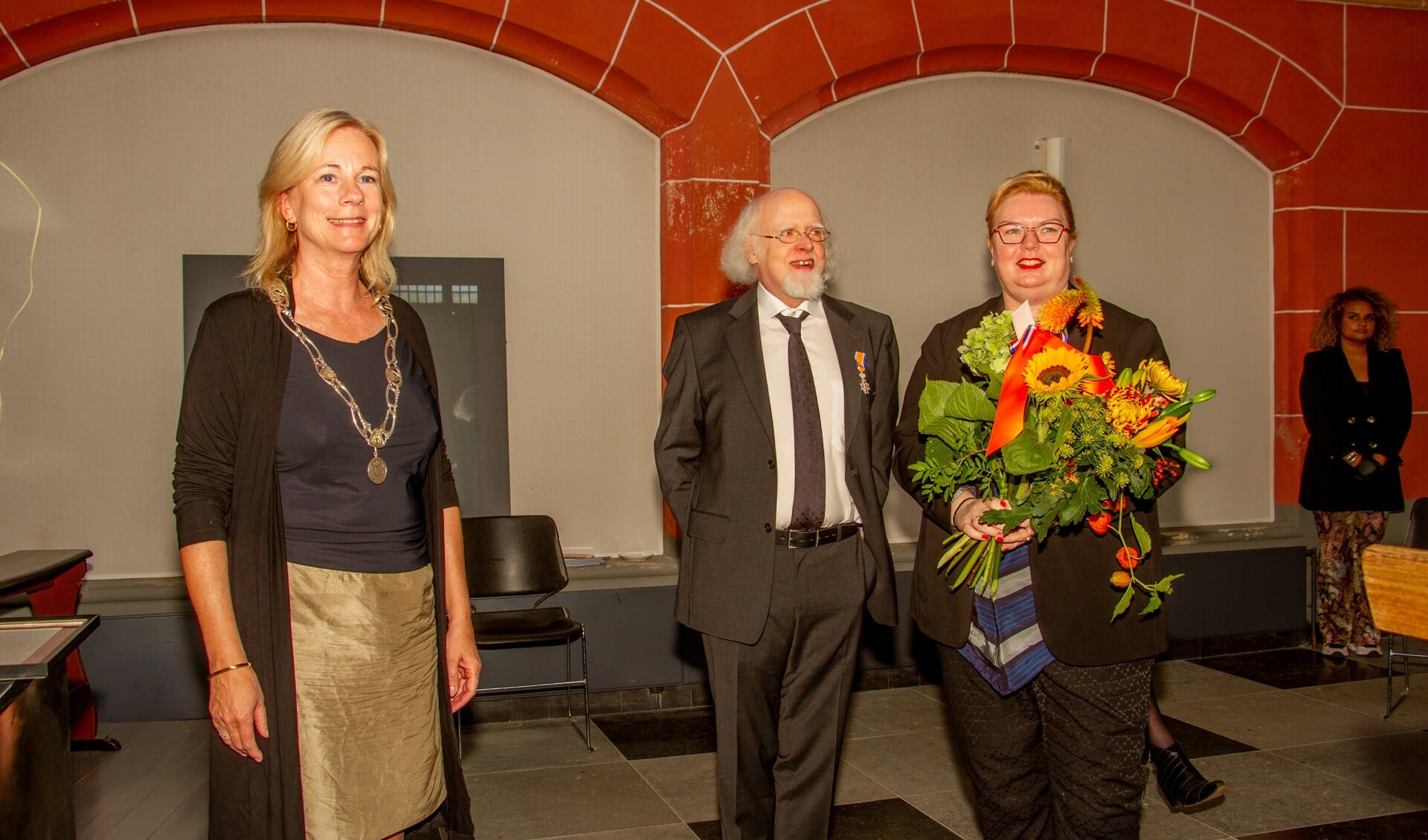 Burgemeester Annemieke Vermeulen mocht Herman van Bosheide koninklijk onderscheiden. Zijn vrouw Heidi kreeg bloemen. Foto: Achterhoekfoto.nl/Liesbeth Spaansen