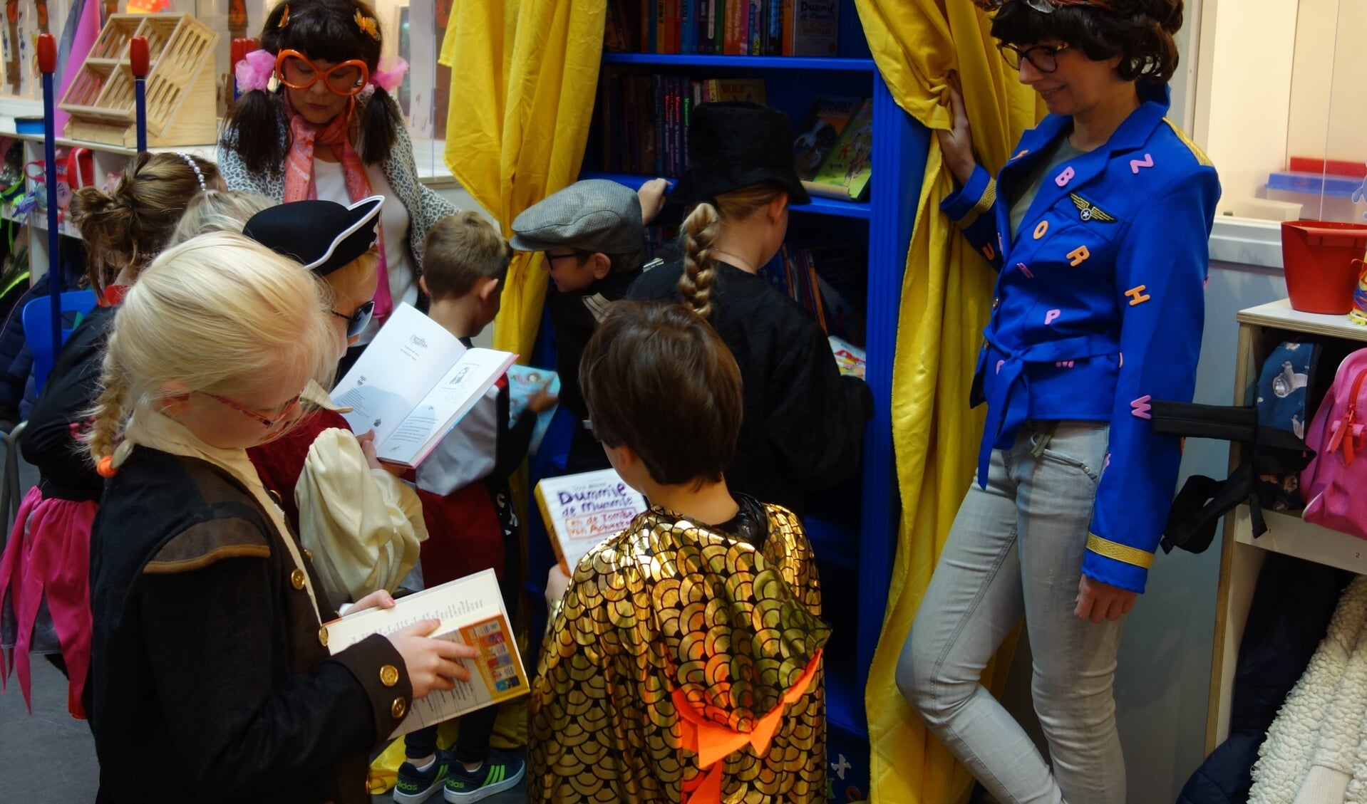 Bea Boekje (links) en Letty Letter laten de kinderen van groep 4 alvast snuffelen tussen de boeken. Foto: Clemens Bielen