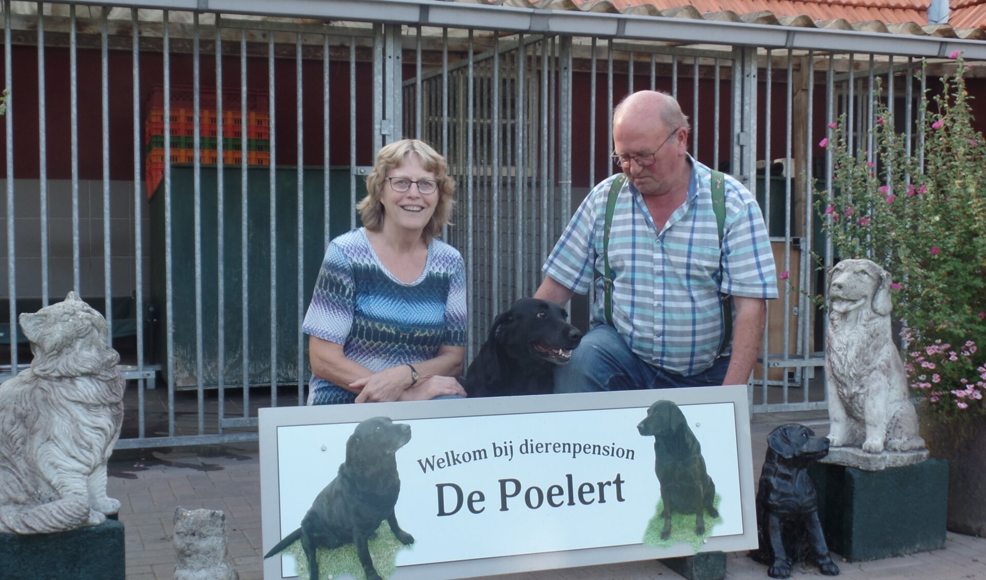 Willie en Henk Velhorst samen met hun hond Tara bij een van de kennels van dierenpension De Poelert. Foto: Jan Hendriksen.