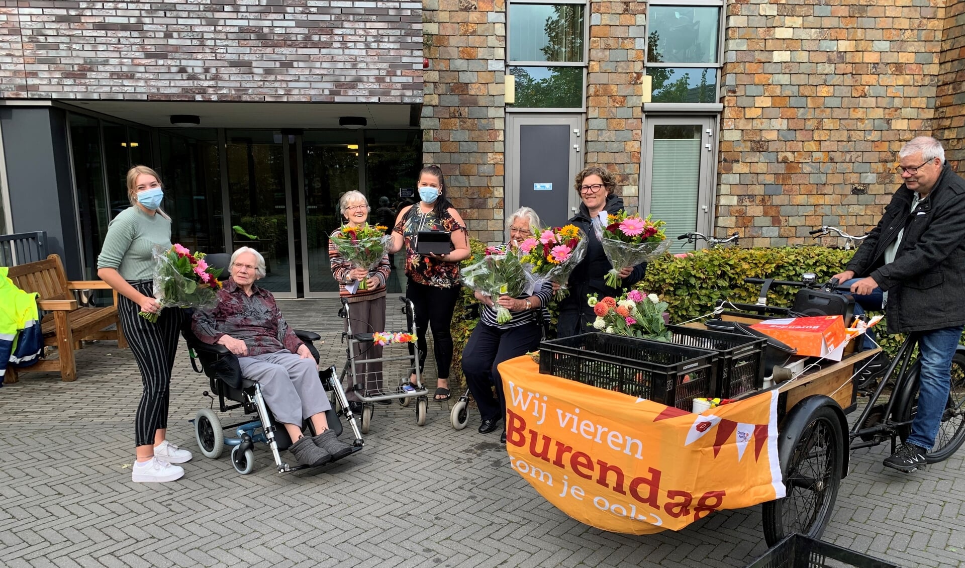 Vrijwilligers van wijkvereniging 't Hooiland gingen met de bakfiets op pad om de bewoners van de Mariënhof een bloemetje te bezorgen in het kader van Burendag 2020. Foto: PR Hooiland