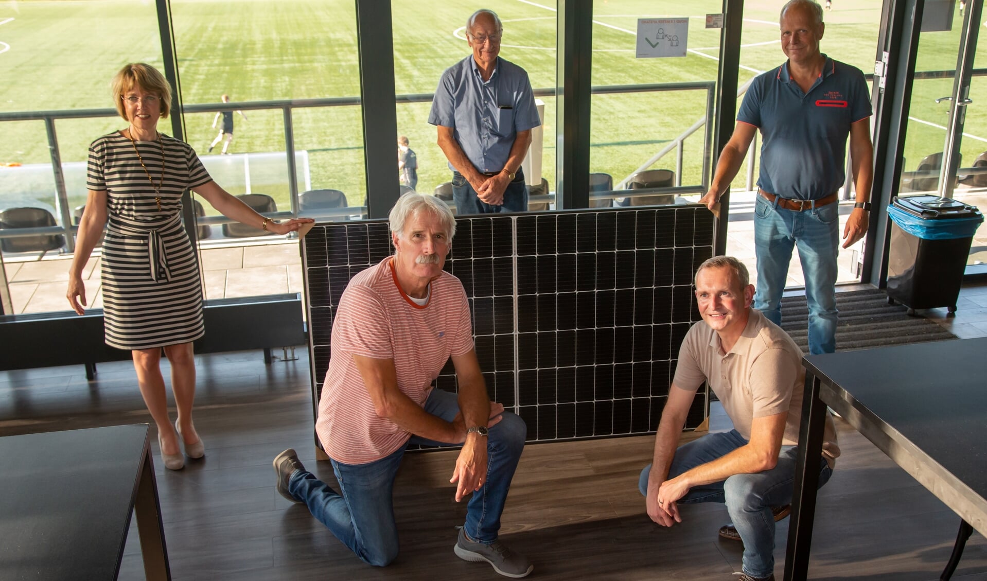 Wethouder Tineke Zomer, Hans Huls, Johan Mentink (staand van links naar rechts) en Gerrit te Kolste en Leon Klein Tank (knielend van links naar rechts) bij een van de zonnepanelen. Foto: Marco ter Haar