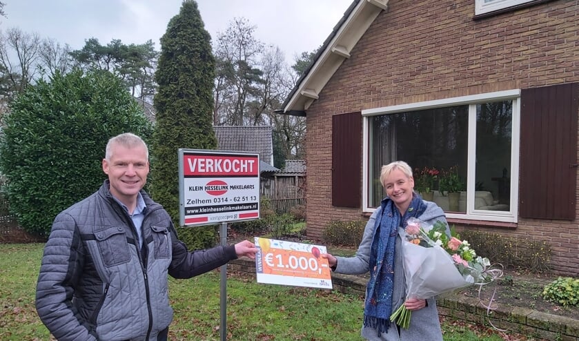 <p>Ellen Zemmelink ontving namens de familie, uit handen van makelaar Alfred Beeftink een cheque met de geldprijs. Foto: PR</p>