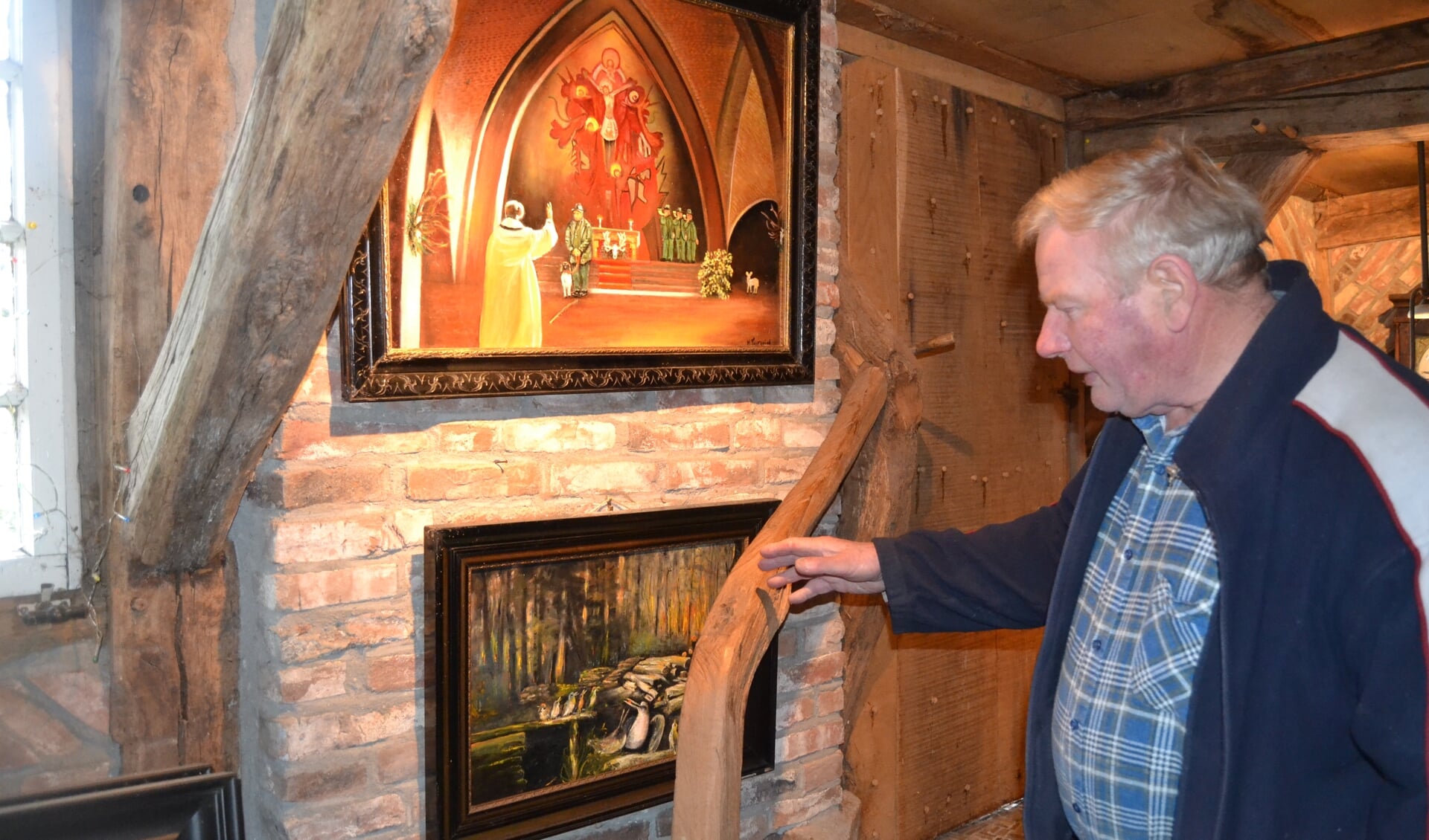 Herman Testerink in de schuur bij twee van zijn schilderijen. Foto: Karin Stronks
