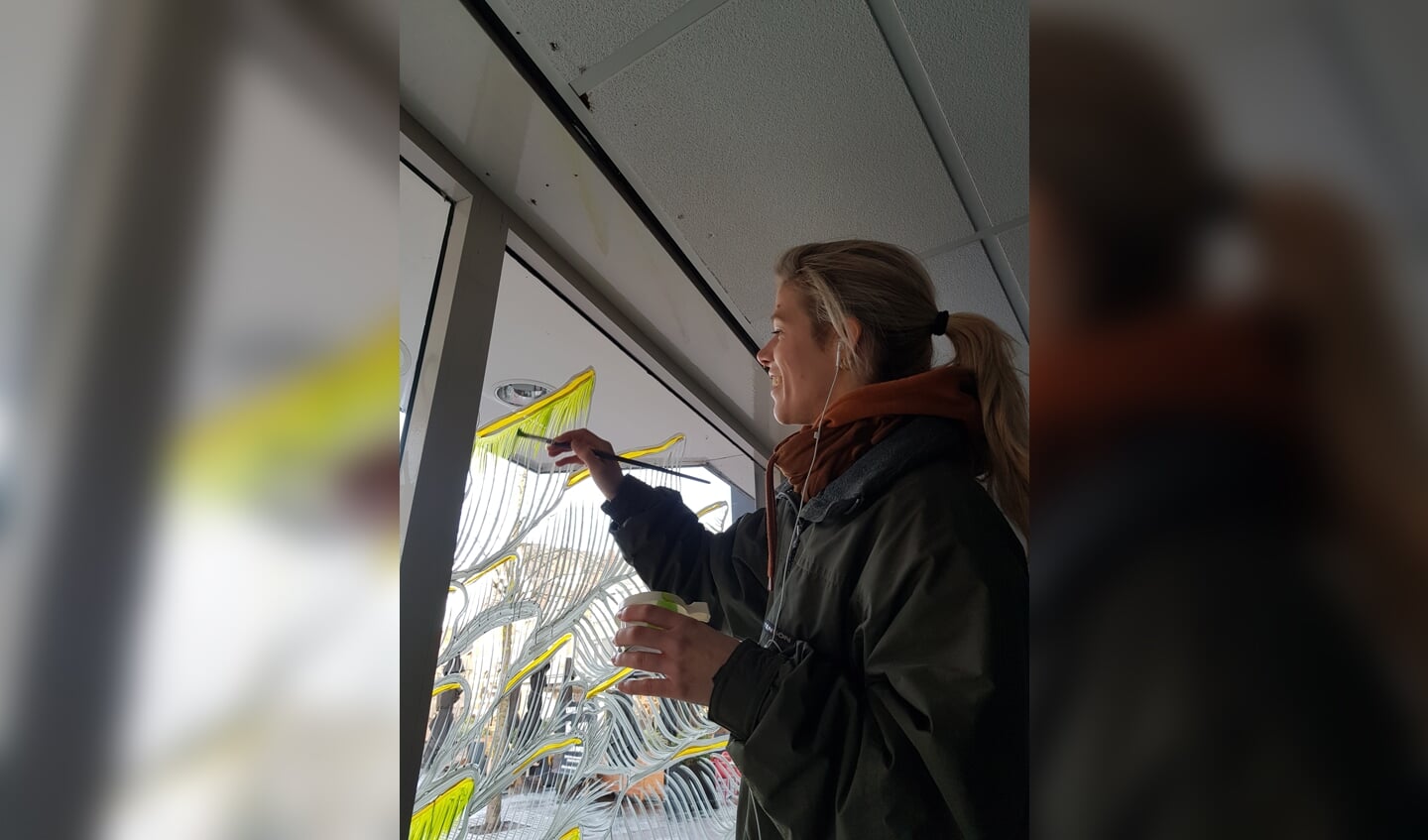 Marloes de Kiewit werkt aan de raamschildering. Foto: Geef Lichtenvoorde Kleur