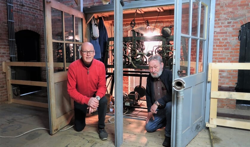 <p>Laurens Kolkman (links) en André Papen bij het torenuurwerk in de Zieuwentse kerk. Foto: Theo Huijskes</p>