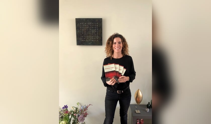 <p>Lot Rohde toont een aantal exemplaren van haar eerste bundel. Eigen foto</p>