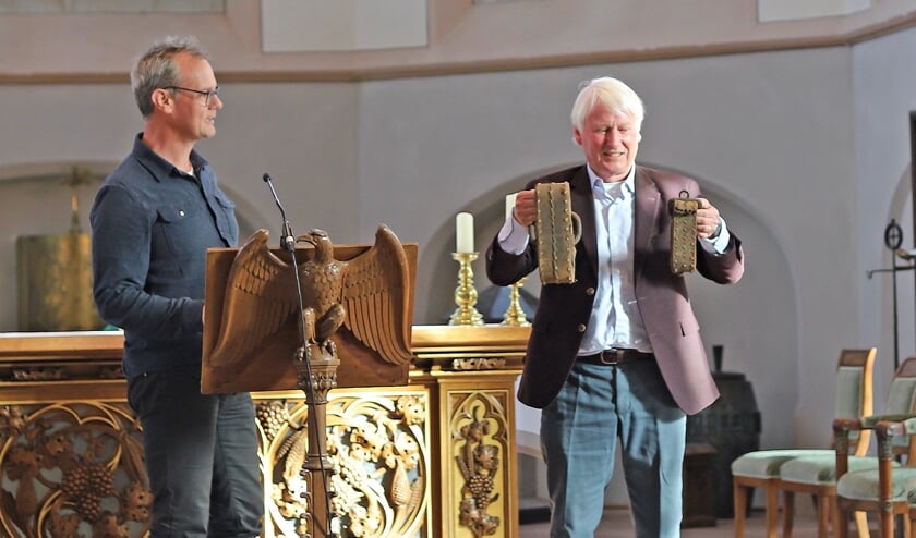 <p>Herman Heuver heeft namens het kerkbestuur de riemen ontvangen van stadsarcheoloog Michel Groothedde. Foto: Sander Grootendorst</p>