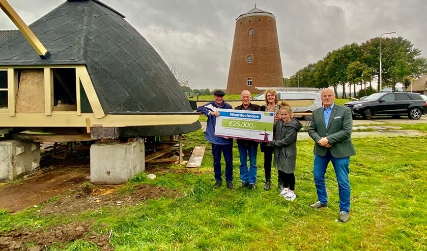 De vrijwilligers van de Braamtse Molen zijn blij met de cheque van 25.000 euro, overhandigd door wethouder Jan van Halteren. Foto: PR