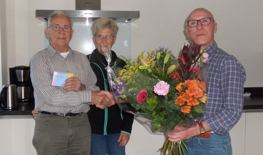 <p>Uit handen van voorzitter Bertus Nijenhuis van EHBO Vorden (r.) ontving jubilaris Martin Wolsing een cadeaubon. Voor zijn vrouw Diny was er een mooie bos bloemen. Foto: PR</p>