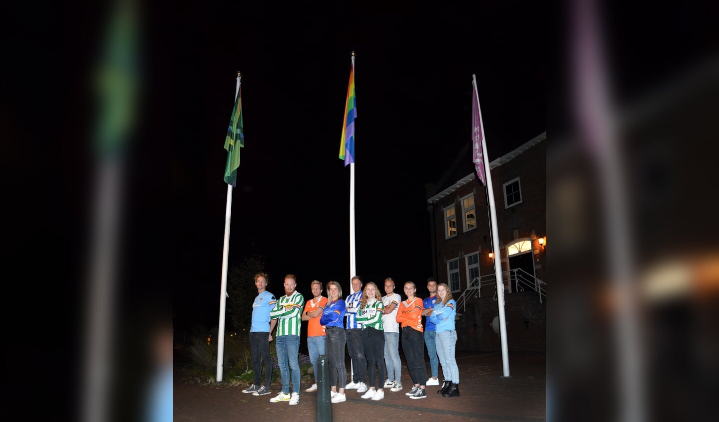 Gezamenlijk poseren onder de regenboogvlag en de Achterhoekse vlag met regenboogaccenten. Foto: Lisa Wellink