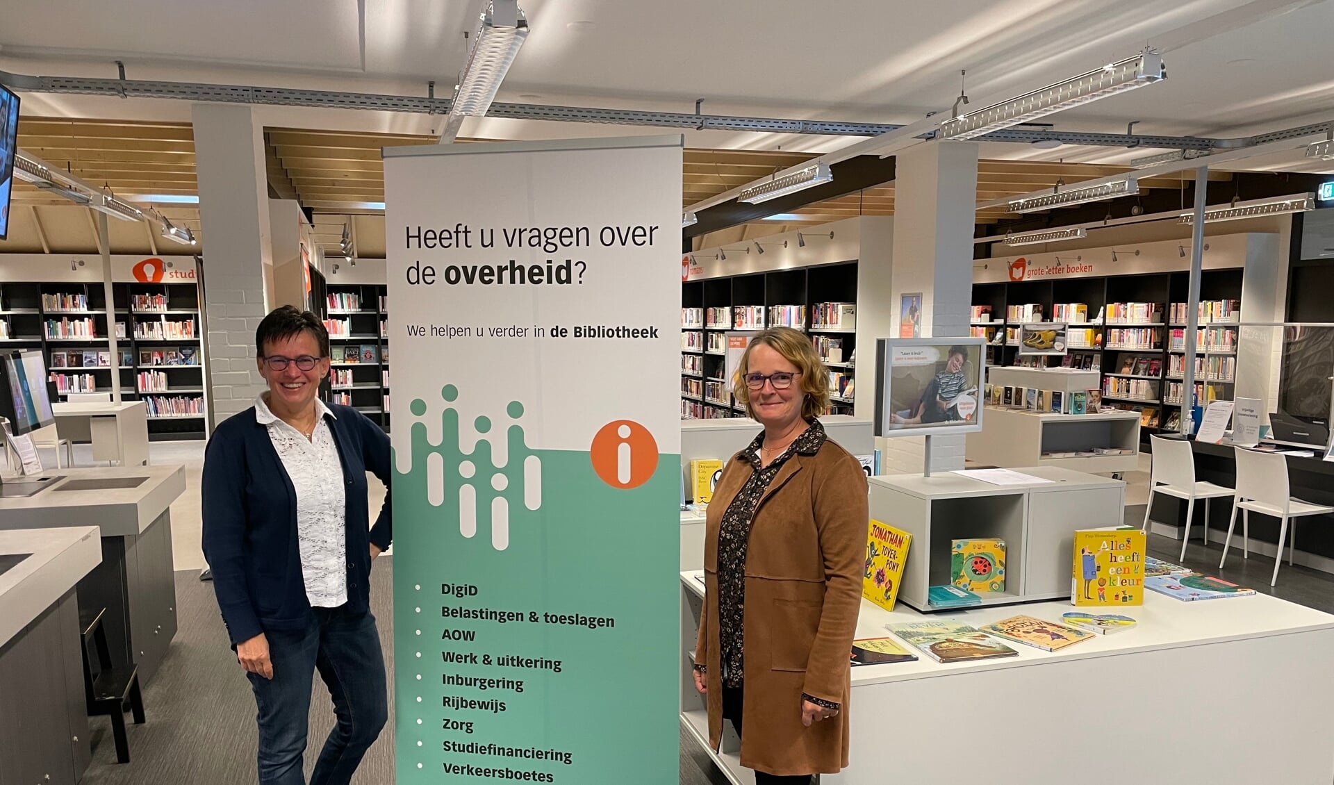 Jody Hagenbeek (l) en Dianne Oldenkamp in de bibliotheek van Lochem. Samen met collega Willy Nijman zijn ze de gezichten van het Informatiepunt Digitale Overheid. Foto: Henri Bruntink  