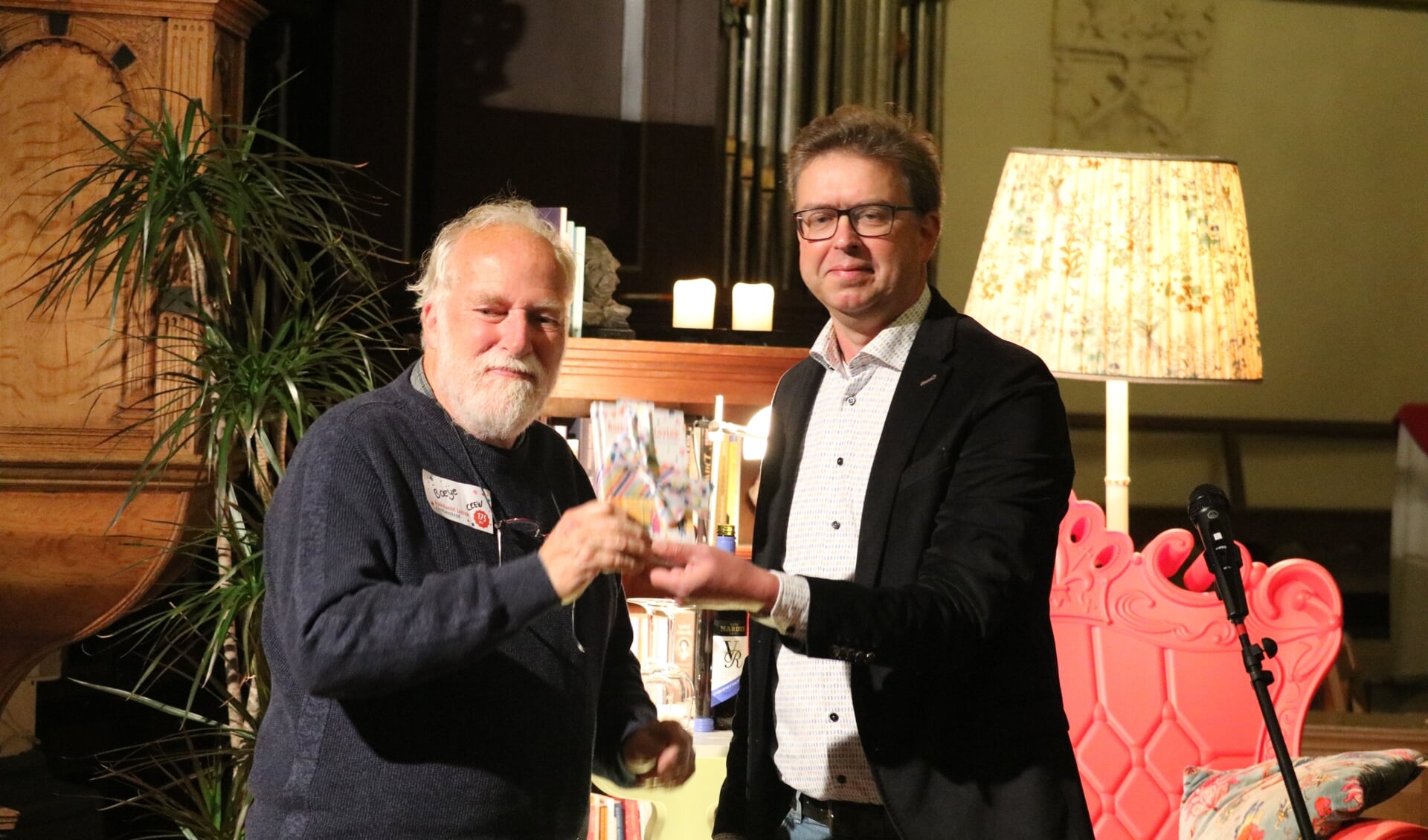 Boeije Jansen (links) ontving het eerste exemplaar van de Feestbundel uit handen van wethouder Henk van Zeijts (GroenLinks). Foto: Arjen Dieperink