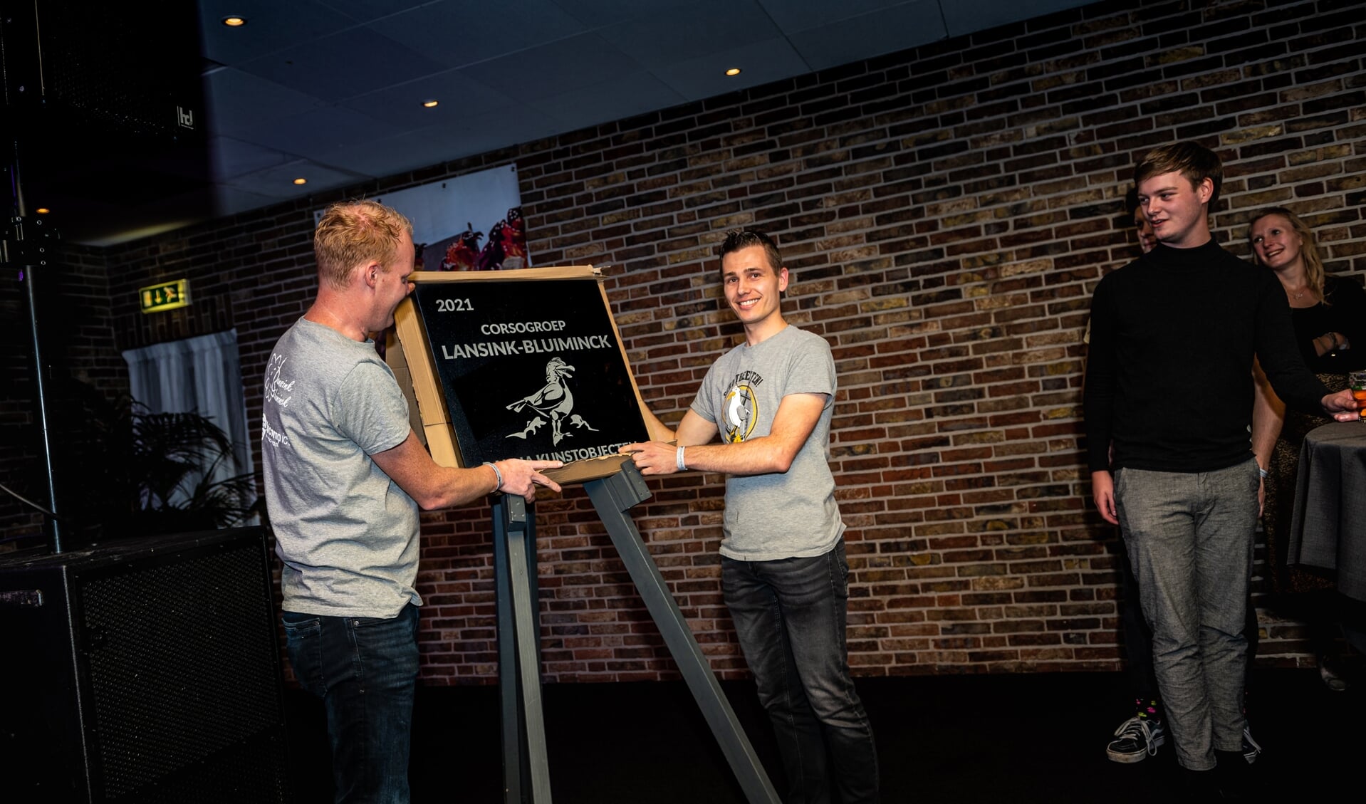 Voorzitter Ewald Berendsen en ontwerper Mark Muller van Lansink-Bluiminck onthullen de plaquette van hun winnende kunstobject ‘Schijtbeesten’.
Foto: Rick Mellink
