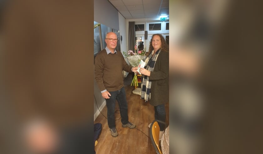 <p>Voorzitter Rigter overhandigt Maartje Hakze de bloemen. Foto: Erik Wildenbeest</p>