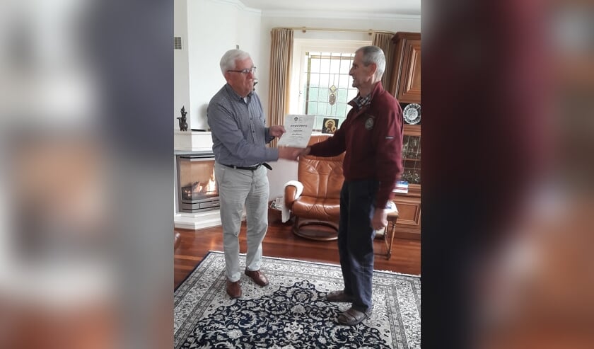 <p>Henk Eijkelkamp overhandigt Jan de oorkonde. Foto: PR</p>