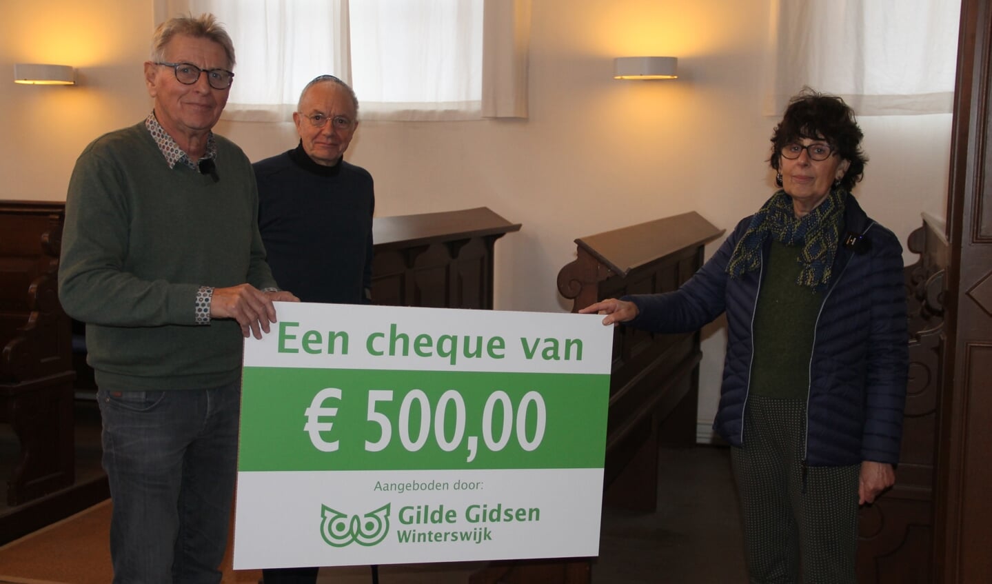 Gert Jan Kuiper (l) en Henk Rösken (m) hebben de cheque van 500 euro aangeboden aan Mirjam Schwarz van de Stichting Winterswijkse Synagoge. Foto Lineke Voltman