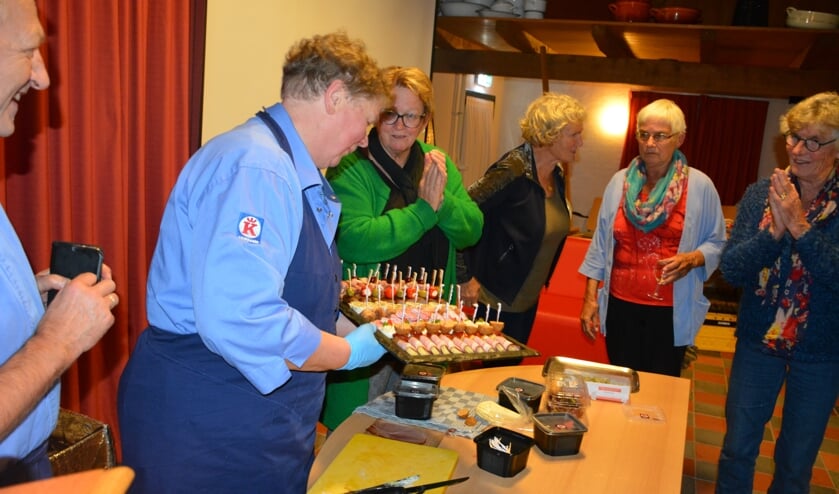 <p>Diny Jansen laat, onder grote belangstelling, zien hoe je snel de lekkerste hapjes kunt maken. Foto: Diny Oosterlaken</p>