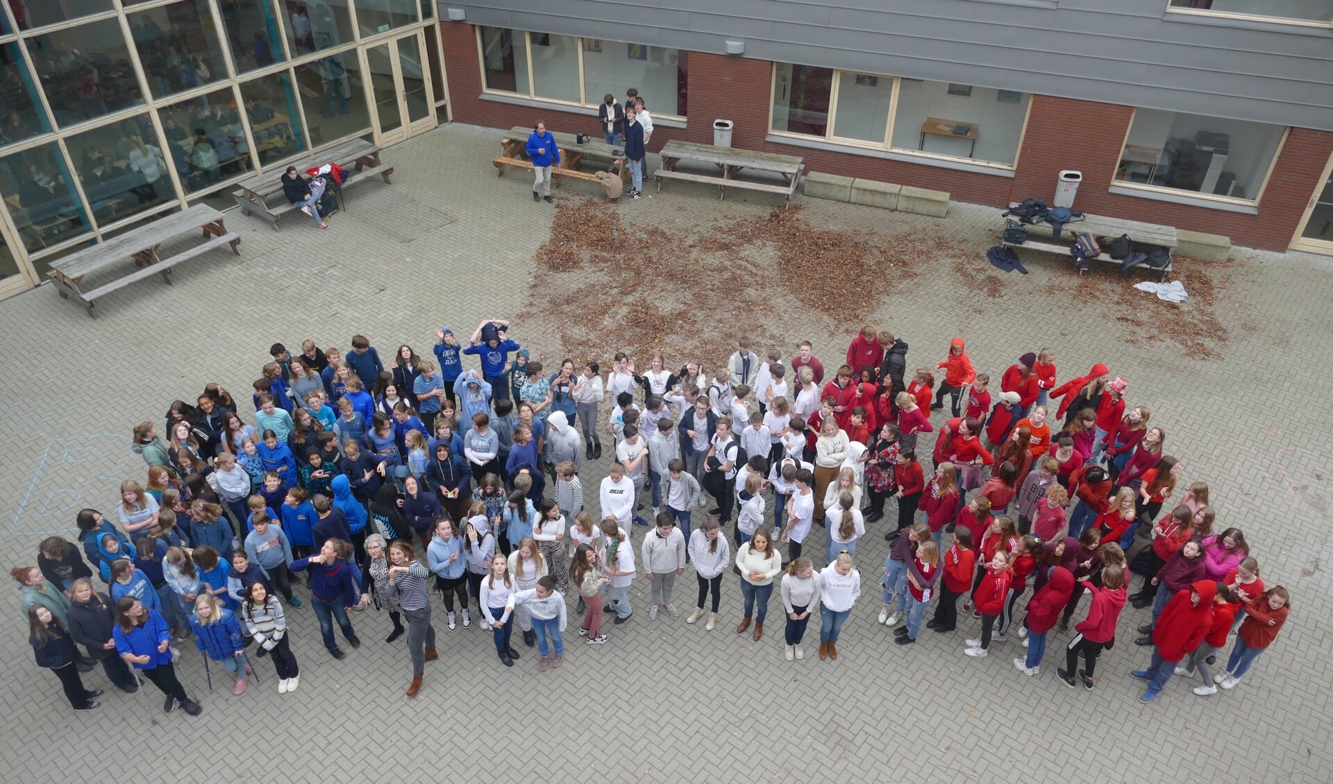 Leerlingen van klas 7 en 8 (brugklas en tweede klas) maakten op het schoolplein een levende Franse vlag door blauwe, witte en rode kleding te dragen. Foto: Vrije School Zutphen