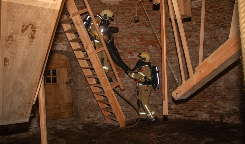 <p>Brandweervrijwilligers brengen via smalle trappen een ‘slachtoffer’ van de hoogste zolder van de molen naar beneden. Foto: Liesbeth Spaansen</p>