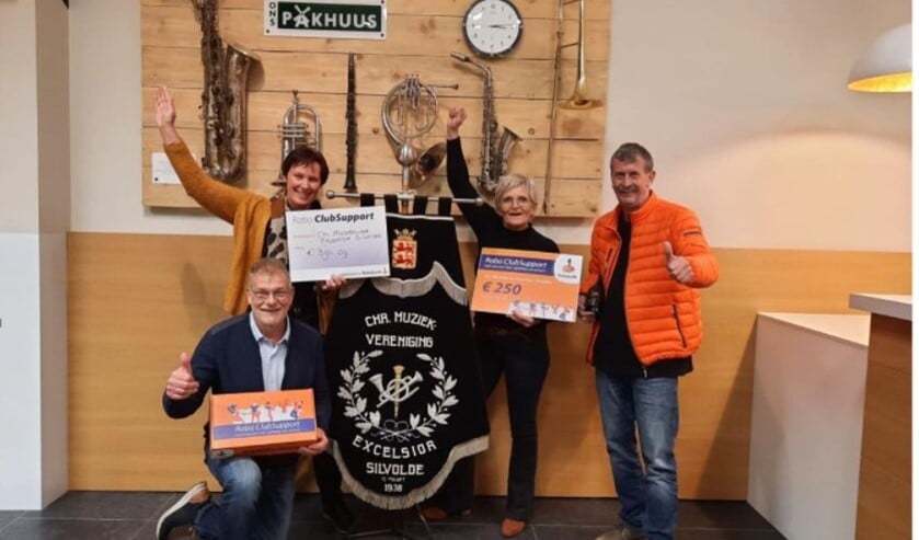 Excelsior kreeg vorige week een cheque overhandigd. Komende zaterdag concerteert de muziekvereniging, online te bekijken. Foto: PR