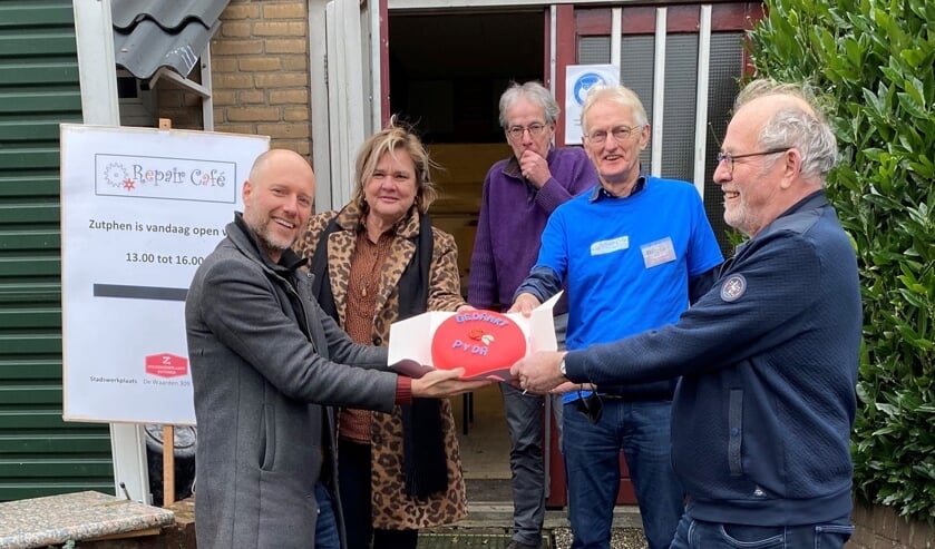 <p>De PvdA reikt de rode taart uit aan vrijwilligers van het Repair Café. Foto: PR</p>  