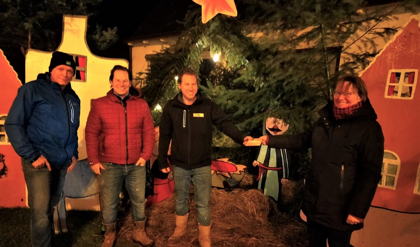 Hermien Groot-Tjooitink (r) overhandigt aan één van de afgevaardigden van de winnaars van 'het Centrum', Pim Bijvank de waardebon ter waarde van 100 euro. Verder op de foto van links naar rechts Henk Pul en Rik Ringenier. Foto: Jan Burgers