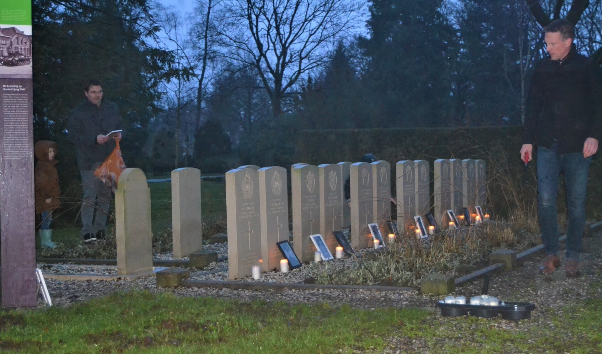 Thijs en Rien plaatsen lichtjes en foto's bij de oorlogsgraven. Foto: Karin Stronks