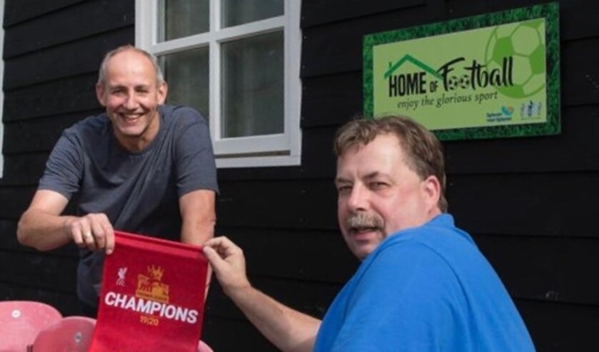 De Graafschap-fan Herben Gerritsen krijgt een Liverpool-kampioensvaan als cadeau, omdat hij de eerste bezoeker was van het vierde seizoen. Foto: PR