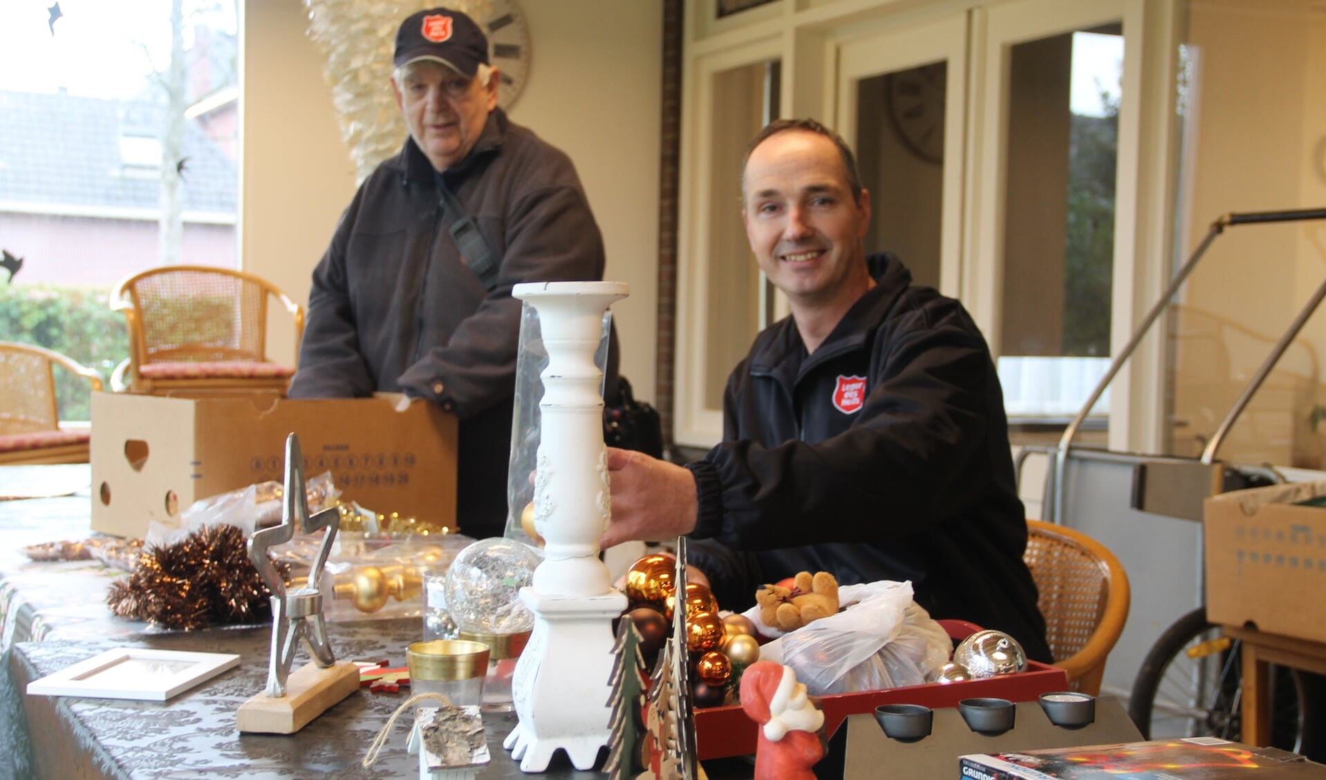 Arnold Vellekoop en vrijwilliger Bernhard bij de tafel met kerstartikelen. Foto Lineke Voltman