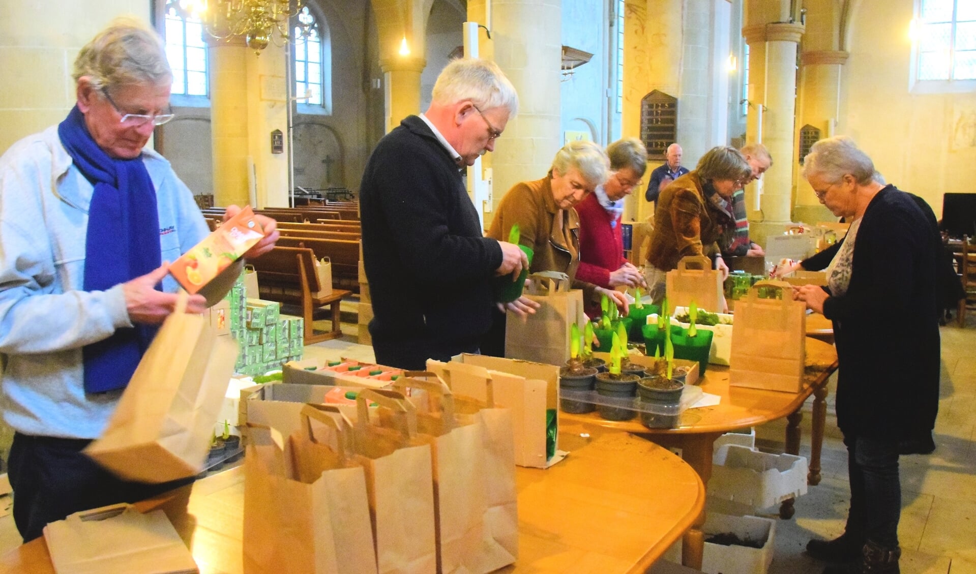 Kersttassen inpakken aan de ‘lopende band’ in de Jacobskerk. Foto Ans ter Horst-Boeijink