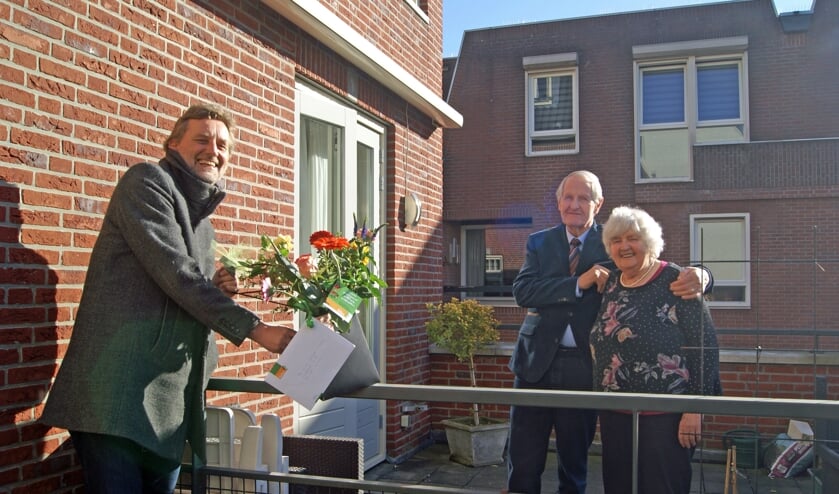 Burgemeester Anton Stapelkamp brengt het diamanten paar Hoftijzer-Te Brake een boeket bloemen. Foto: Eva Schipper