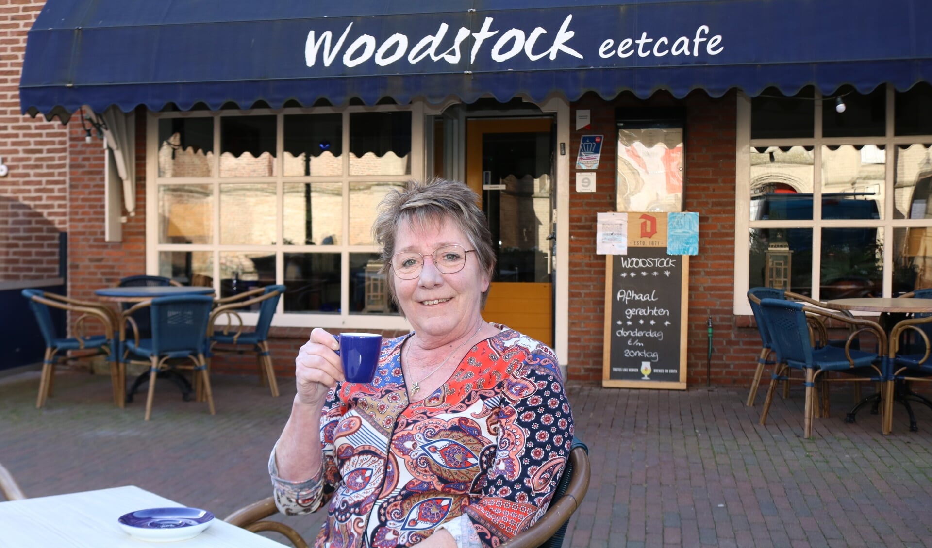 Hendy Brinkert drinkt een kopje koffie op haar eigen terras. Ze vindt dat de terrassen weer open kunnen. Foto: Arjen Dieperink