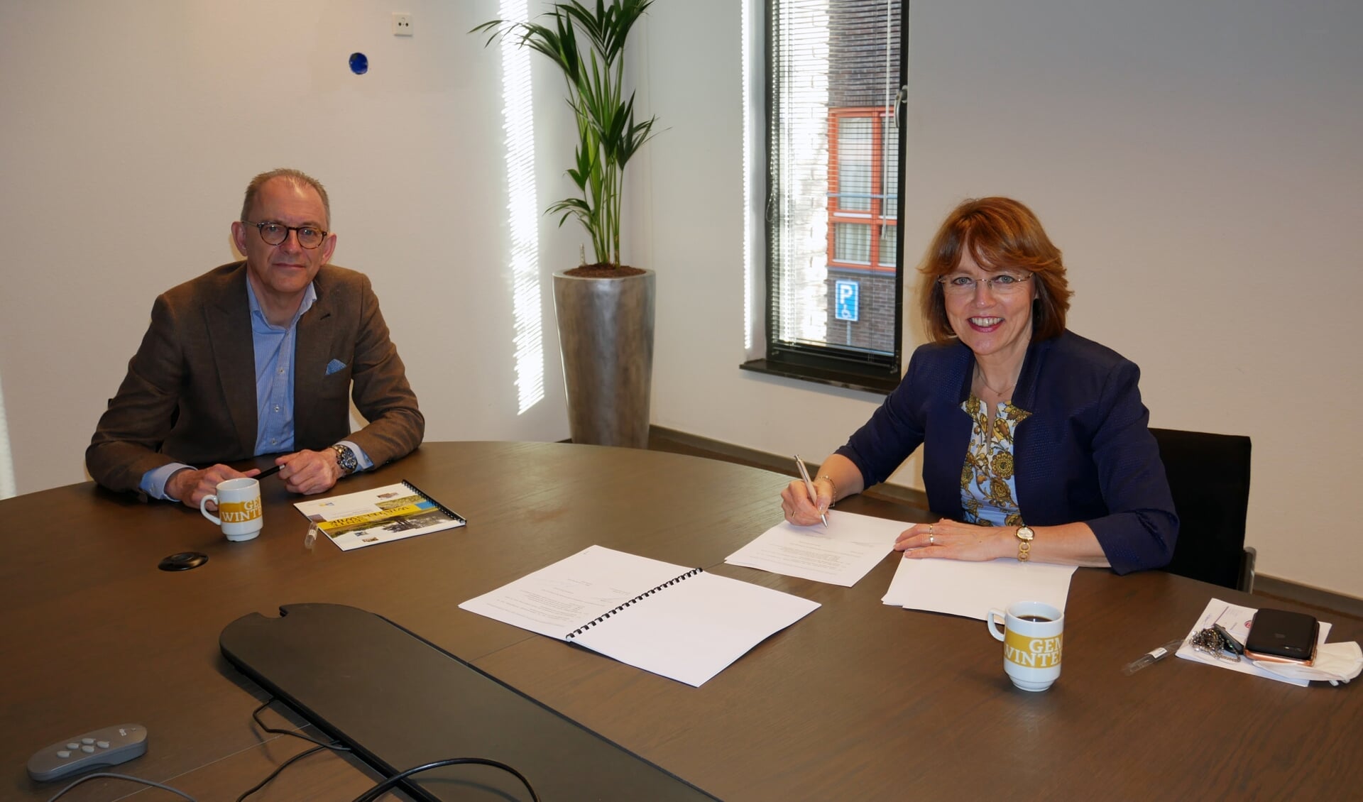 Jan Pieter de Wilde, directeur van Kuster Energy, en Tineke Zomer, wethouder Duurzaamheid van de gemeente Winterswijk ondertekenen het contract. Foto: PR gemeente