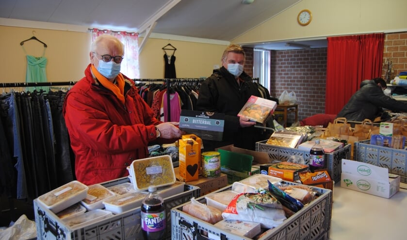 <p>Christiaan Makkinga en Dick de Waard met producten, die ze vrijdag naar de Voedselbank brachten. Foto: Contact</p>