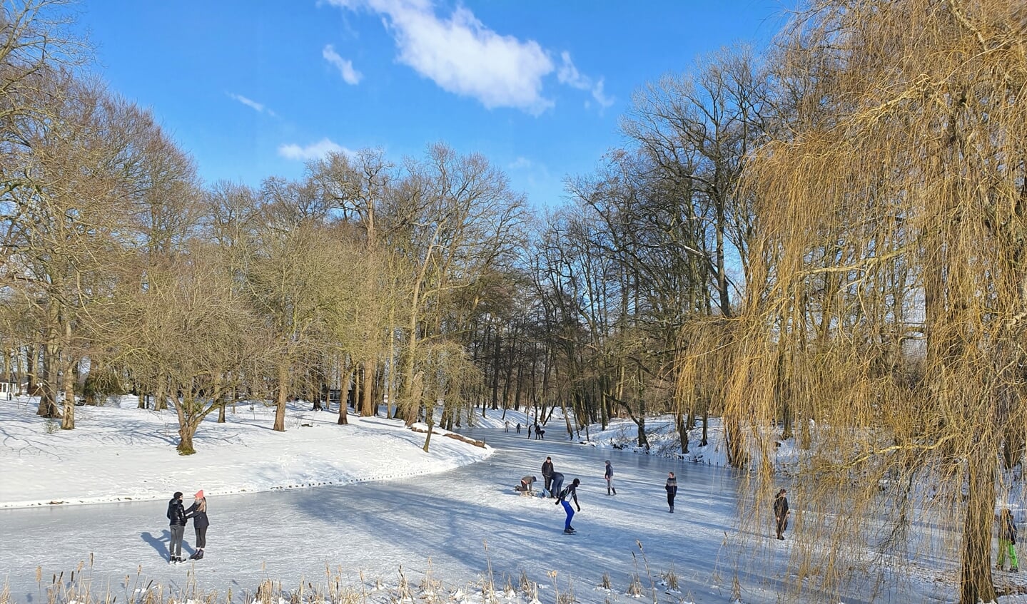 Een handjevol mensen, over het algemeen kinderen, geniet vrijdagmiddag op een zonovergoten bevroren gracht om Huize Baak. In het weekend was het vele malen drukker. Foto: Alice Rouwhorst