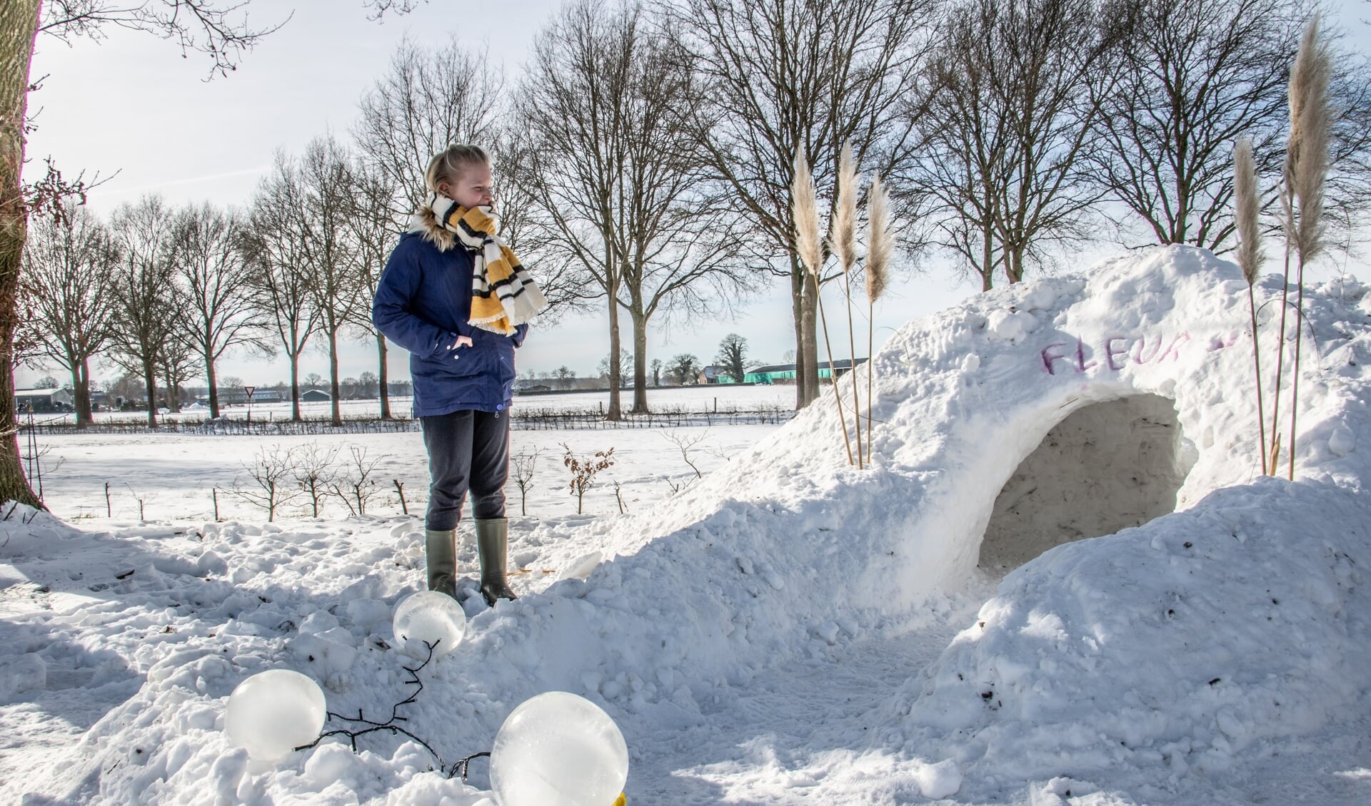 Fleur Huirne is trots op haar iglo. De ijsbollampjes verlichten het pad mooi. Foto: Achterhoekfoto.nl/Liesbeth Spaansen