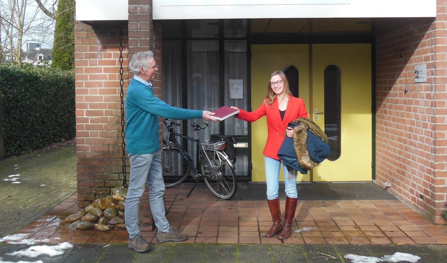 Penningmeester Gerrit Vlogman reikt corona-proof de aanmoedigingsprijs uit aan Carlijn Heersink voor het Old Vorden Huus. Foto: Oud Vorden