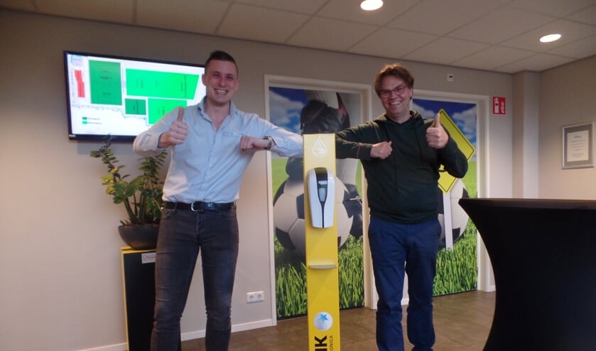 <p>Kasper van Bindsbergen bood VV Ruurlo een dispenser voor desinfecterende handgel in de clubkleuren aan Foto: Jan Hendriksen</p>