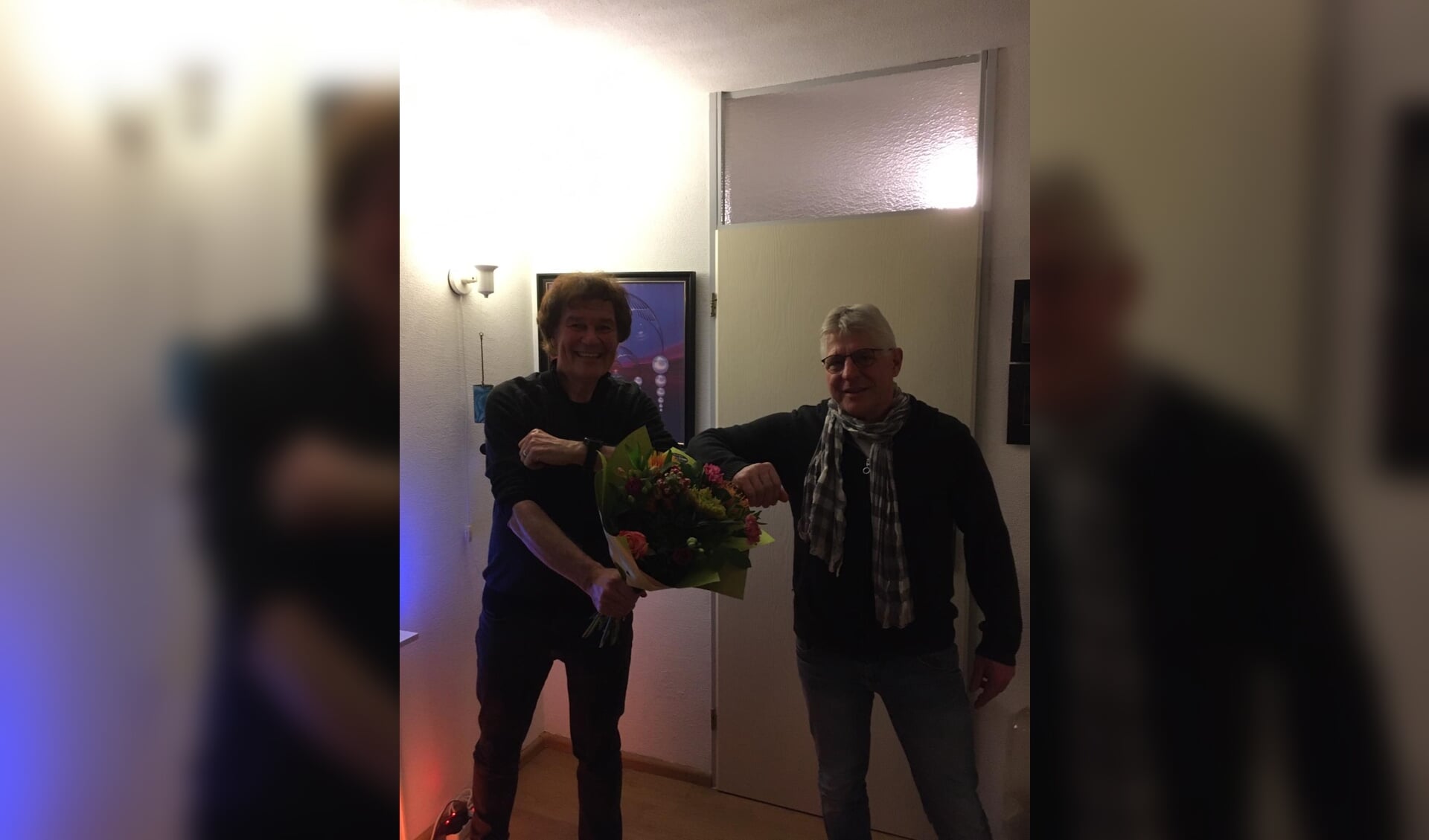 Theo Wierdsma (l) ontving uit handen van voorzitter Jan Nijenhuis van de Stichting 4-5 mei Commissie Ruurlo een mooie bos bloemen en een horloge. Foto: PR 