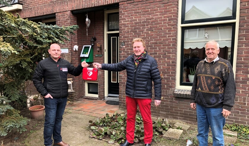 De overhandiging van de buurt-AED in de Kortestraat, van links naar rechts, initiatiefnemer Richard Oberink, Johan G. Esendam, voorzitter Hart4Winterswijk en Johnny Lens waar de AED hangt. Foto: Wim Kos.