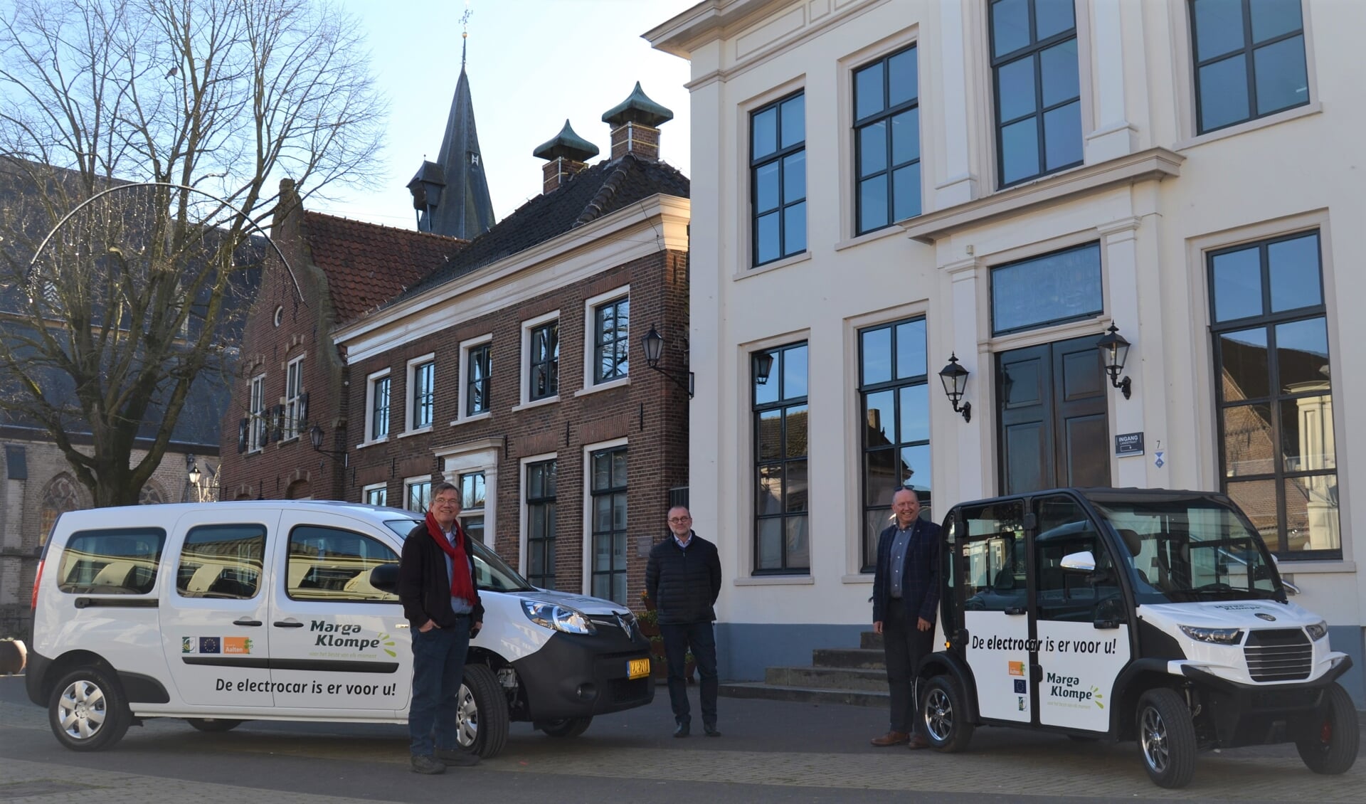 Links wethouder Joop Wikkerink met Henk Hogevonder en Hans Onstenk van Marga Klompé bij de nieuwe electrocar en de elektrische auto. Foto: Karin Stronks