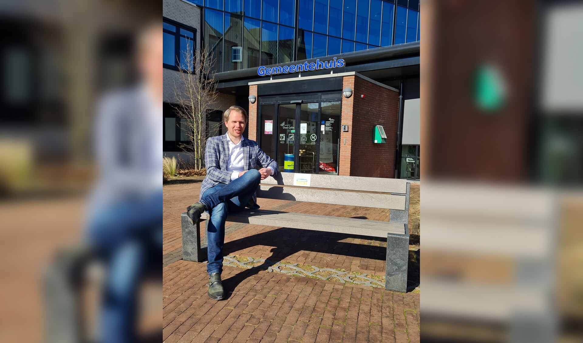 Wethouder Bart Porskamp op het bankje voor het gemeentehuis in Lichtenvoorde. Foto: