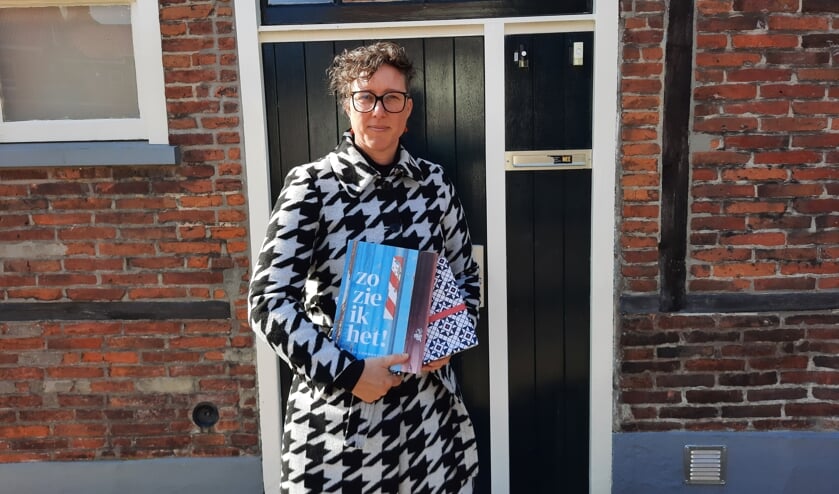 <p>Linda Commandeur met haar nieuwste boek. Eén exemplaar is alvast verpakt in het nieuwe Grolse Wanten-inpakpier. Foto: Kyra Broshuis</p>