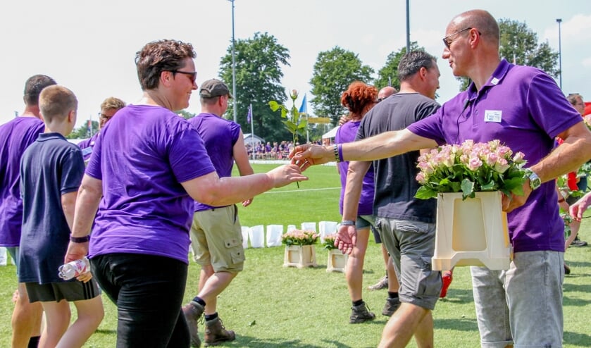 Dirk Hiddink (r.) deelt rozen uit aan deelnemers, na 24 uur SamenLoop voor Hoop Bronckhorst, 2018. Foto: Liesbeth Spaansen