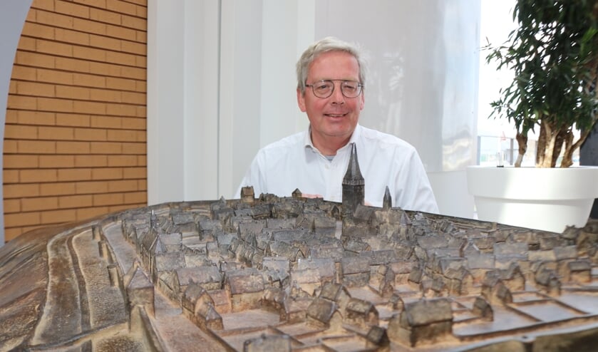 <p>Paul Roodbol bij het kunstwerk dat Lochem voor de stadsbrand in1615 weergeeft. Foto: Arjen Dieperink</p>